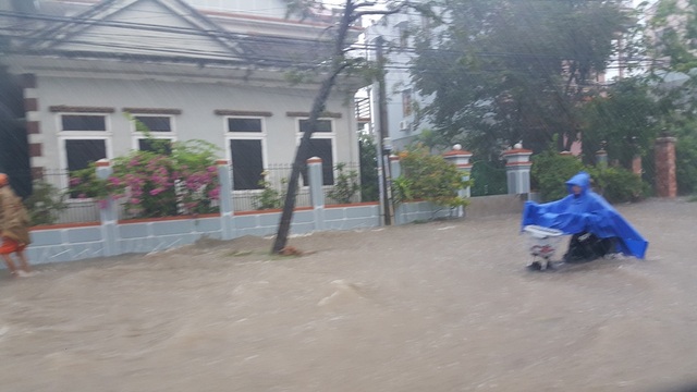 Mưa cực lớn, Huế ngập thành "sông" - 3 Một em học sinh lội về giữa biển nước nguy hiểm