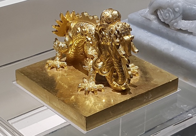 64 Bảo vật hoàng cung triều Nguyễn lần đầu về lại cố hương - 2 Ấn “Quốc gia tín bảo” bằng vàng thời vua Gia Long (1802-1819) dùng cho các văn kiện triệu tập các tướng lĩnh, phát động binh sĩ, trưng binh nhập ngũ và các văn kiện hành chính quan trọng. Ấn có cạnh 11,7x11,7cm, cao 9cm, dày 1,65cm.