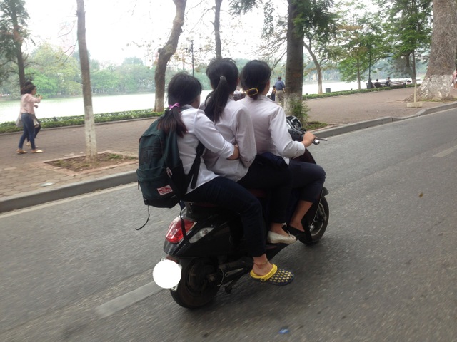 Hà Nội: Học sinh đầu trần, mũ treo xe, vô tư phạm luật giao thông - 5
Học sinh đi xe gắn máy, chở ba và không đội mũ bảo hiểm vẫn nhởn nhơ tham gia giao thông. (Ảnh chụp trên đường Đinh Tiên Hoàng vào ngày 7/4/2017)