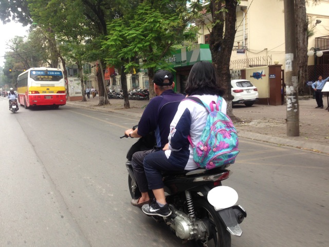 Hà Nội: Học sinh đầu trần, mũ treo xe, vô tư phạm luật giao thông - 9
Thậm chí, một số phụ huynh đi đón con cũng không đội mũ bảo hiểm. (Ảnh chụp vào ngày 7/4/2017).