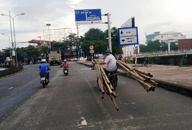 Xe thô sơ chở hàng cồng kềnh nghênh ngang trên đường - 1 Xe xích lô 3 bánh chở luồng dài hơn chục mét nghênh ngang trên đường thành phố Ninh Bình.