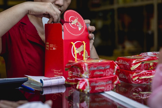 Cận Trung thu, người Hà Nội xếp hàng dài để mua bánh nướng, bánh dẻo - 6 Tại cửa hàng, các nhân viên luôn tay xếp bánh cho khách. Trong quầy, rất đông nhân viên đóng hộp, tìm bánh theo đúng nhu cầu khách mua.