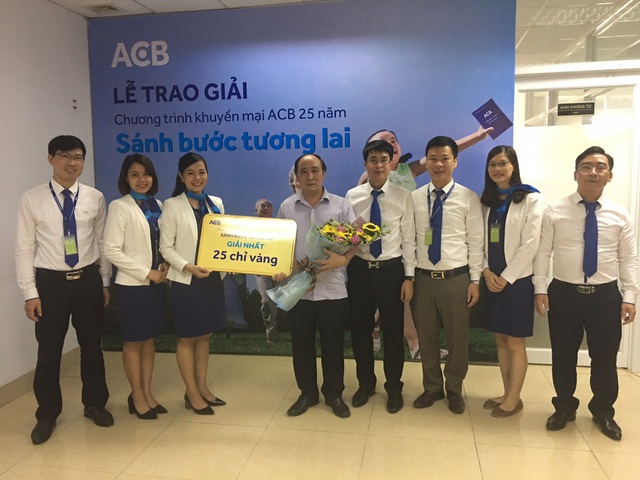 Khách hàng trúng giải thưởng to khi gửi tiết kiệm tại ACB - 2 Tập thể nhân viên và lãnh đạo ACB - Chi nhánh Hà Nam cùng chúc mừng và chia sẻ niềm vui với khách hàng Nguyễn Mạnh Tuyển (tỉnh Hà Nam). Anh là một trong 5 khách hàng nhận giải nhất 25 chỉ vàng của chương trình.