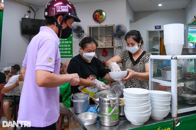 Hàng ăn sáng ở Hà Nội đông đúc, người dân xếp hàng chờ được ăn phở tại quán - 1