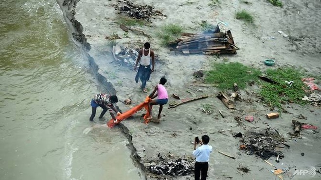 Nước lũ dâng làm lộ hàng trăm thi thể bên sông thiêng ở Ấn Độ - 1
