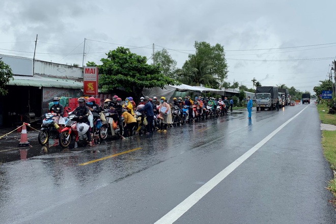 Hàng trăm người dân chạy xe máy từ vùng dịch về quê dưới trời mưa tầm tã  - 1