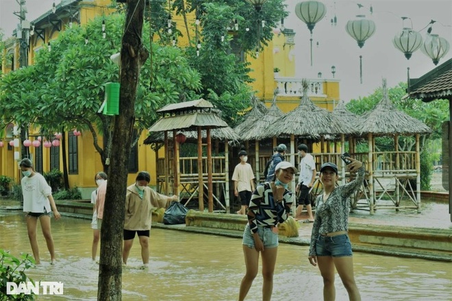 Young people check in Hoi An ancient town in flood season - 4