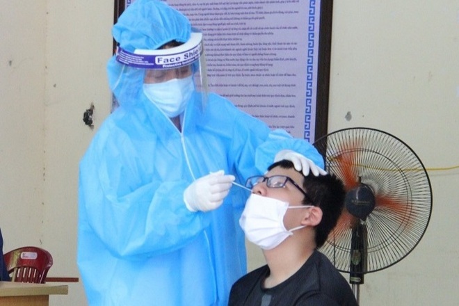 Nhân viên y tế dùng một que tăm bông lấy mẫu test Covid-19 cho nhiều người - 1