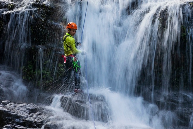 Visitors enjoy swinging over a waterfall more than 50 m high in the middle of the old forest in Quang Binh - 4