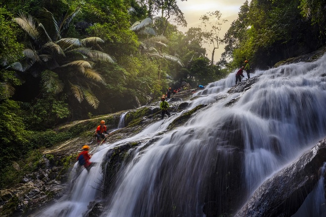 Visitors enjoy swinging over a waterfall over 50 meters high in the middle of the old forest in Quang Binh - 3