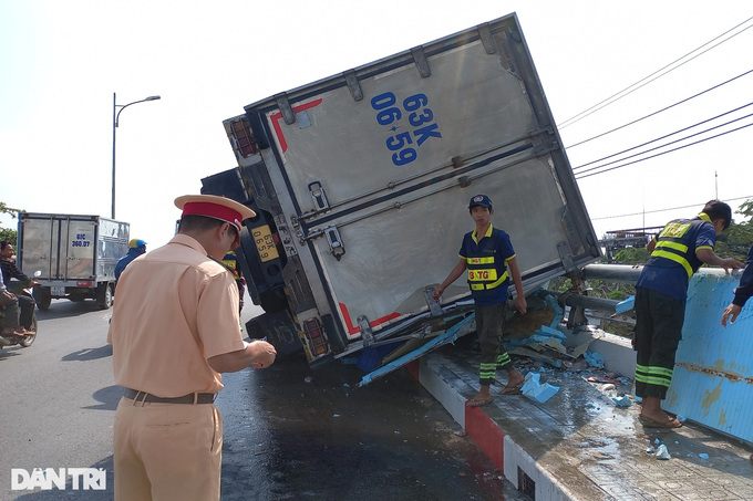 Xe tải lật ngang cầu, người dân giúp tài xế gom gần 8 tấn cá - 1