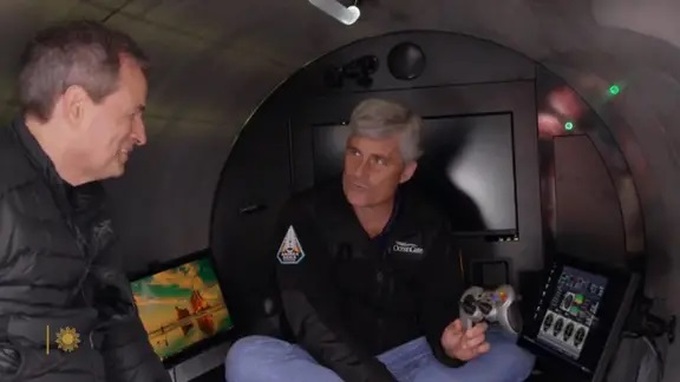 Stockton Rush (phải) khoe với phóng viên David Pogue về tay cầm điều khiển của tàu ngầm Titan (Ảnh: CBS News).