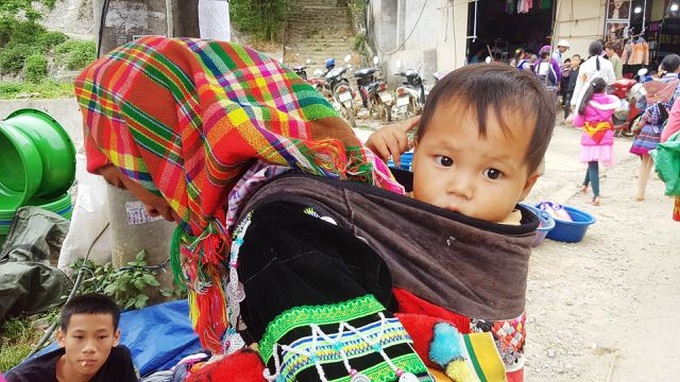 Children carried by mothers at Bac Ha Market - 5