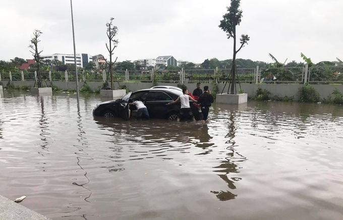 Cars submerged after heavy rains in Hanoi - 2