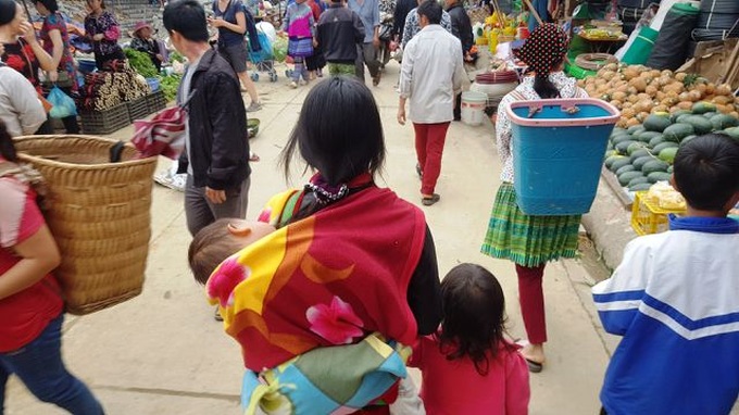 Children carried by mothers at Bac Ha Market - 2