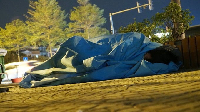 Homeless people struggle through Hanoi cold night - 2