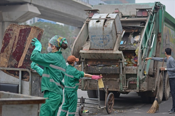 Sanitary workers hurry to clean up Hanoi streets after dump site blockage - 3