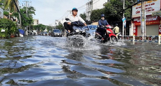 Traffic chaos on HCM City streets following heavy rain - 1