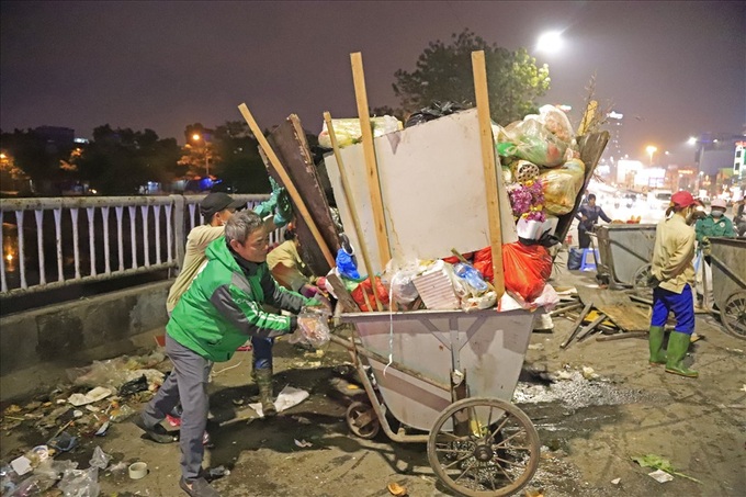 Sanitary workers hurry to clean up Hanoi streets after dump site blockage - 5