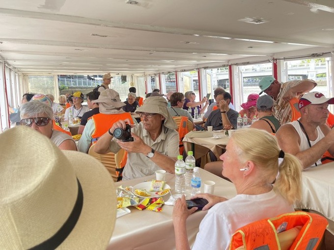 Foreign tourists experience HCM City boat tour - 1