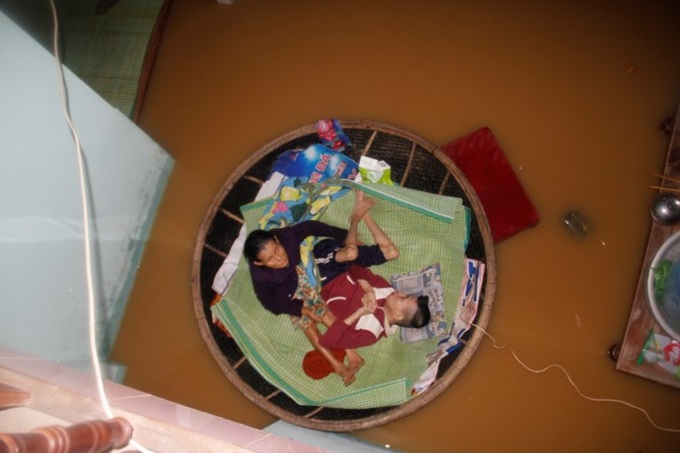 Elderly mother looks after Agent Orange son in flood - 2