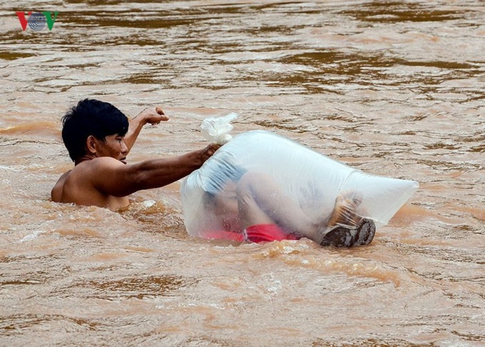Schoolchildren cross stream in plastic bags - 1