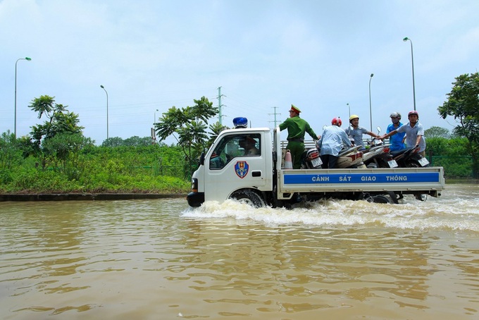 Hanoi traffic police help people on flooded road - 7