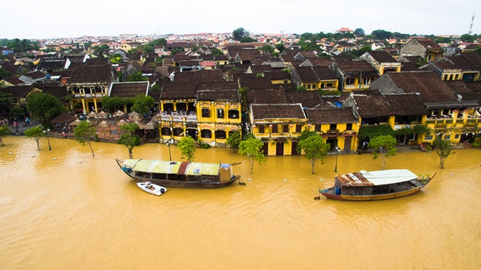 Foreign travellers enjoy exploring Hoi An in flooding - 1