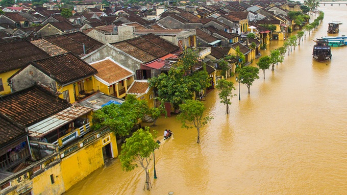 Foreign travellers enjoy exploring Hoi An in flooding - 3