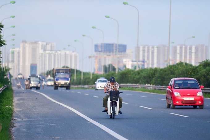 Motorbike drivers risk their lives on Hanoi highway - 6