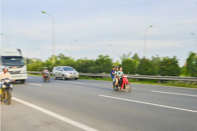 Motorbike drivers risk their lives on Hanoi highway - 7