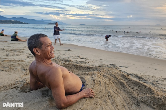 Nha Trang residents bury themselves in sand at dawn - 1