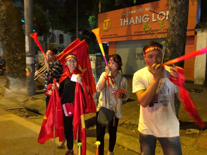 Nhiều sinh viên tranh thủ ra đường bán cờ, băng rôn kiếm thêm thu nhập. (Ảnh: Hồng Vân)