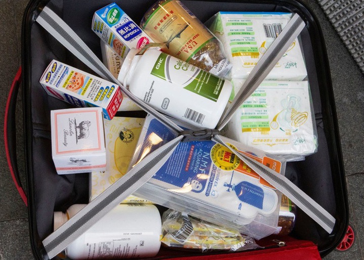 Người Hong Kong phàn nàn rằng người đại lục làm xáo trộn cuộc sống của họ từ việc mua toàn bộ thuốc men, sữa bột trẻ em, thậm chí băng vệ sinh tại các cửa hiệu (Ảnh: New York Times)