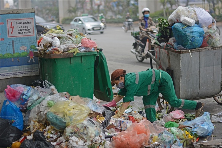 Sanitary workers hurry to clean up Hanoi streets after dump site blockage - 1