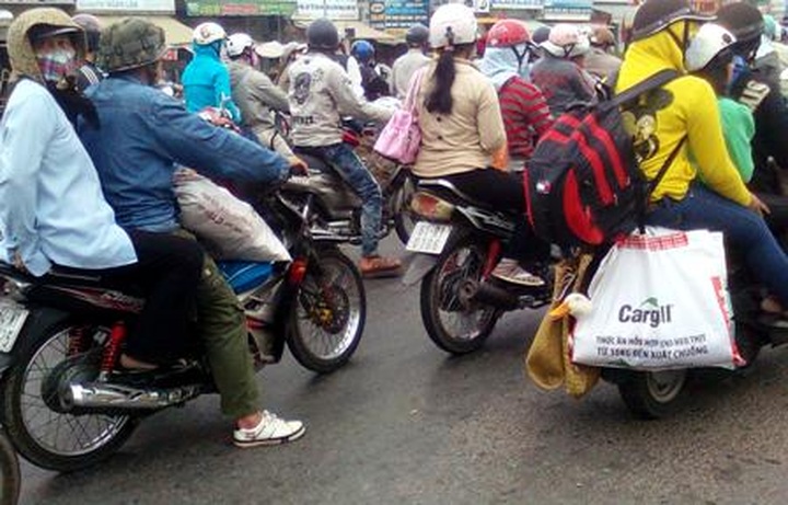 Lack of cars forces people to travel to HCMC by motorbikes after Tet - 4