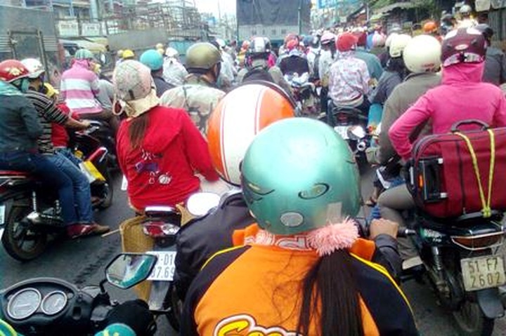 Lack of cars forces people to travel to HCMC by motorbikes after Tet - 3