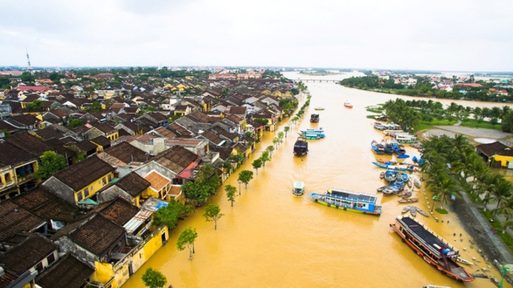 Foreign travellers enjoy exploring Hoi An in flooding - 9