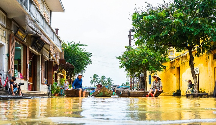 Foreign travellers enjoy exploring Hoi An in flooding - 11
