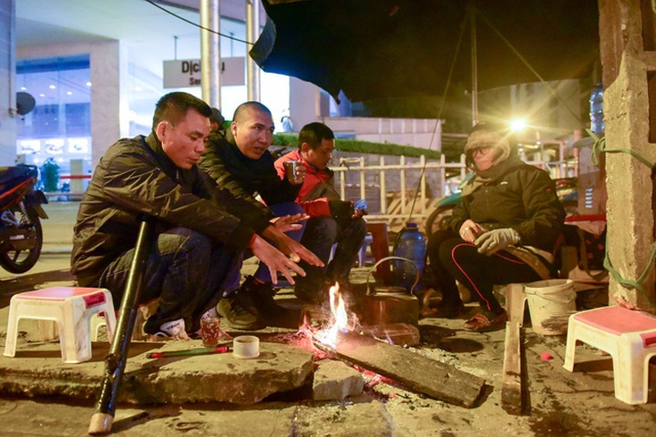Hanoi night workers struggle with chilly weather - 1