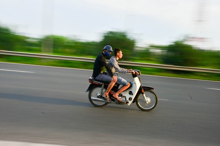 Motorbike drivers risk their lives on Hanoi highway - 5