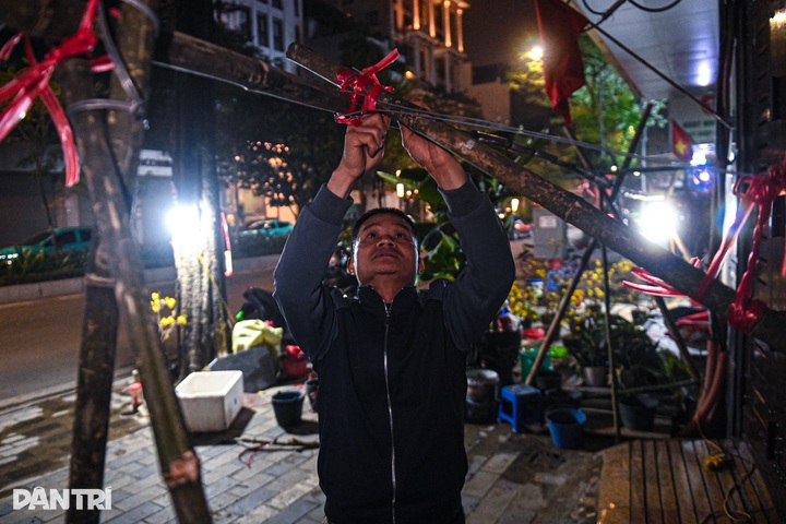 Vendors camp overnight to guard Tet flowers on Hanoi streets - 3