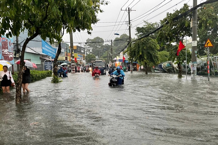 Heavy rain floods major roads in HCM City, vehicles stalled - 2