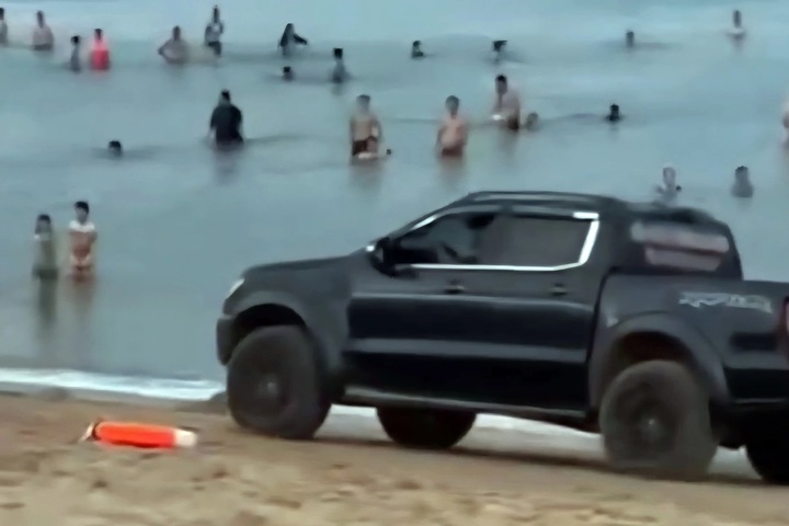 Dak Lak driver fined for driving SUV onto crowded beach - 2