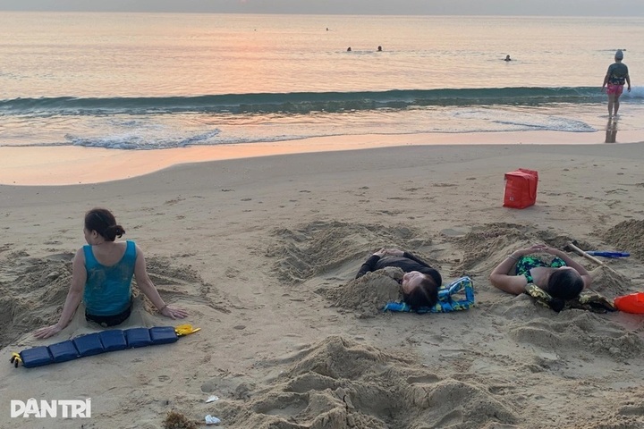 Quang Ngai people bury themselves in sand as healing method - 3
