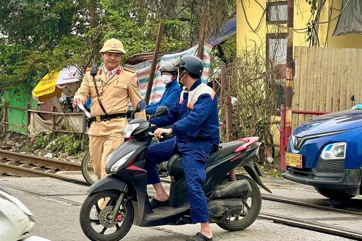 Hanoi traffic police fine drivers for breaching railway barriers - 1