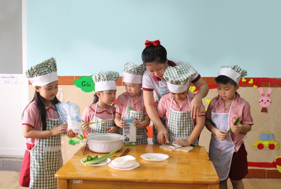 Dạy trẻ về Tết cổ truyền tại trường Saigon Academy - 4 Các bạn nhỏ cùng cô thực hiện món mứt dừa cho ngày tết. Bạn nào cũng rất tập trung theo dõi