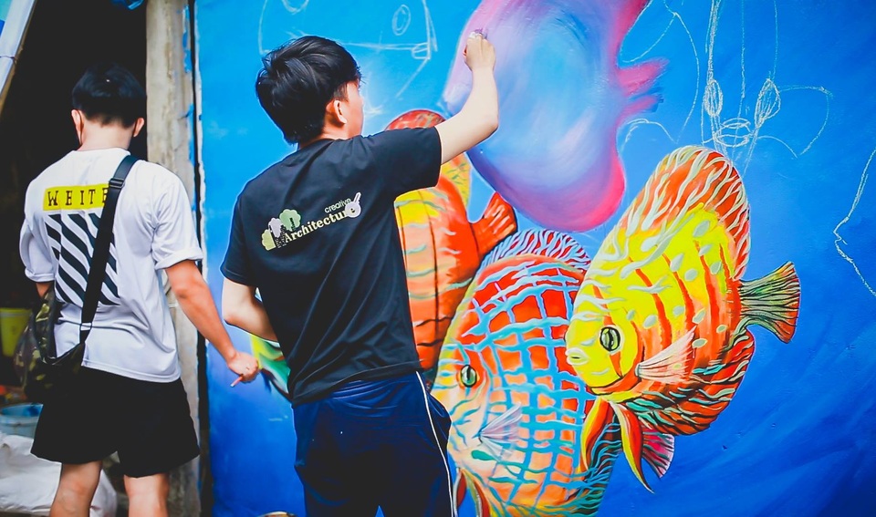 Quảng Nam: Bất ngờ trước vẻ đẹp rực rỡ của làng bích họa tại Tam Hải - 1 Những sinh viên tài hoa của ĐH Bách khoa Đà Nẵng đang “thổi hồn” vào bức bích họa ở Tam Hải.