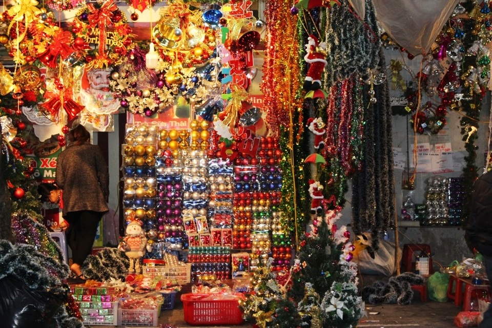 Càng gần đến Giáng sinh, lượng người đổ về phố Hàng Mã càng lớn. Cả một dãy phố, cửa hàng nào cũng bày bán các món hàng trang trí Noel như vòng nguyệt quế, cây thông, chuông, đèn led, quả châu cùng hàng trăm món phụ kiện khiến con đường trở nên vô cùng lấp lánh.