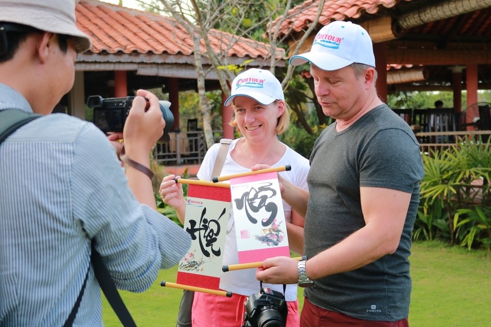 Du khách thích thú trải nghiệm Tết Việt - 6 Khách du lịch chụp hình với những bức thư pháp